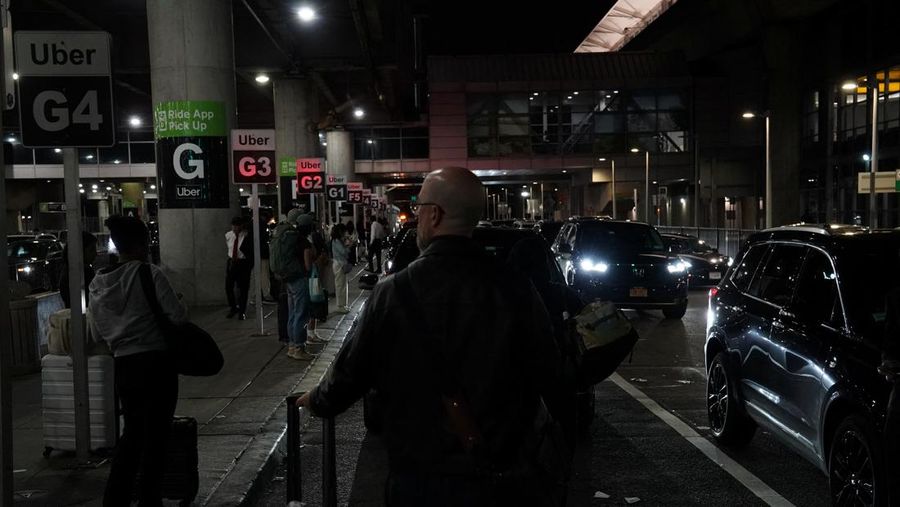 USA-TRAVEL/ A traveler waits for his vehicle at an Uber passenger pick-up area at Terminal 8 at John F. Kennedy International Airport, ahead of U.S. President Donald Trump?s reinstatement of a new travel ban barring citizens of 12 countries from entering the U.S., in New York, U.S., June 8, 2025. REUTERS/Bing Guan