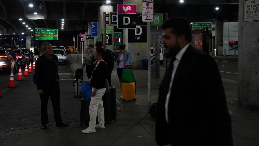 A traveler waits for his vehicle at an Uber passenger pick-up area at Terminal 8 at John F. Kennedy International Airport, ahead of U.S. President Donald Trump?s reinstatement of a new travel ban barring citizens of 12 countries from entering the U.S., in New York, U.S., June 8, 2025. REUTERS/Bing Guan