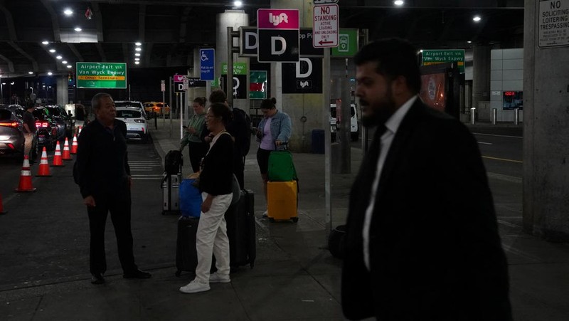 A traveler waits for his vehicle at an Uber passenger pick-up area at Terminal 8 at John F. Kennedy International Airport, ahead of U.S. President Donald Trump?s reinstatement of a new travel ban barring citizens of 12 countries from entering the U.S., in New York, U.S., June 8, 2025. REUTERS/Bing Guan