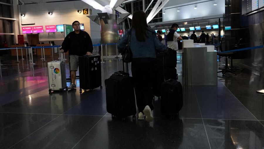 USA-TRAVEL/ A traveler waits for his vehicle at an Uber passenger pick-up area at Terminal 8 at John F. Kennedy International Airport, ahead of U.S. President Donald Trump?s reinstatement of a new travel ban barring citizens of 12 countries from entering the U.S., in New York, U.S., June 8, 2025. REUTERS/Bing Guan