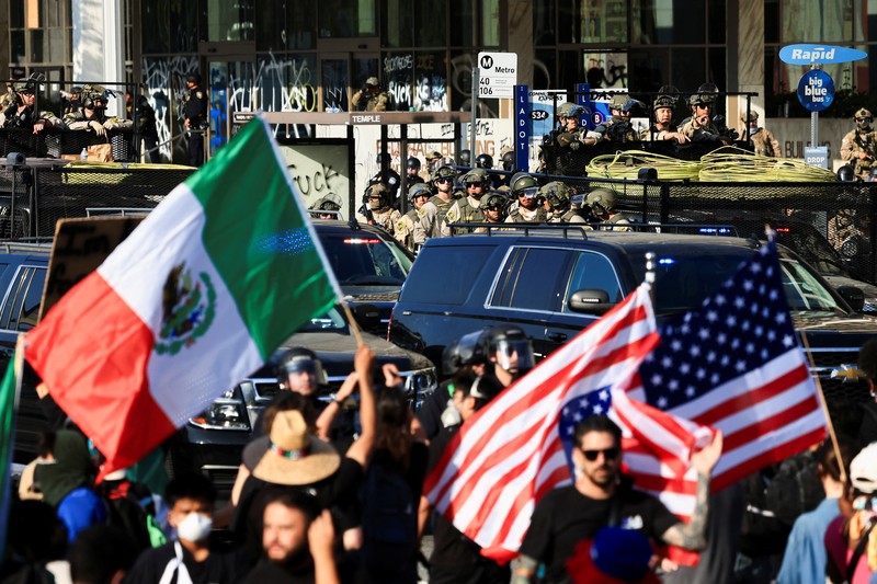 Para demonstran berkumpul di depan pasukan Garda Nasional California dan petugas penegak hukum, saat protes terhadap pemeriksaan imigrasi berlanjut, di Los Angeles, California, AS, 9 Juni 2025. Para demonstran berkumpul di depan pasukan Garda Nasional California dan petugas penegak hukum, saat protes terhadap pemeriksaan imigrasi berlanjut, di Los Angeles, California, AS, 9 Juni 2025. (REUTERS/Daniel Cole)