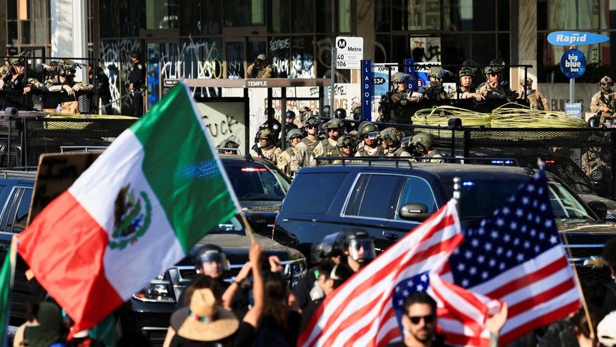 Para demonstran berkumpul di depan pasukan Garda Nasional California dan petugas penegak hukum, saat protes terhadap pemeriksaan imigrasi berlanjut, di Los Angeles, California, AS, 9 Juni 2025. Para demonstran berkumpul di depan pasukan Garda Nasional California dan petugas penegak hukum, saat protes terhadap pemeriksaan imigrasi berlanjut, di Los Angeles, California, AS, 9 Juni 2025. (REUTERS/Daniel Cole)
