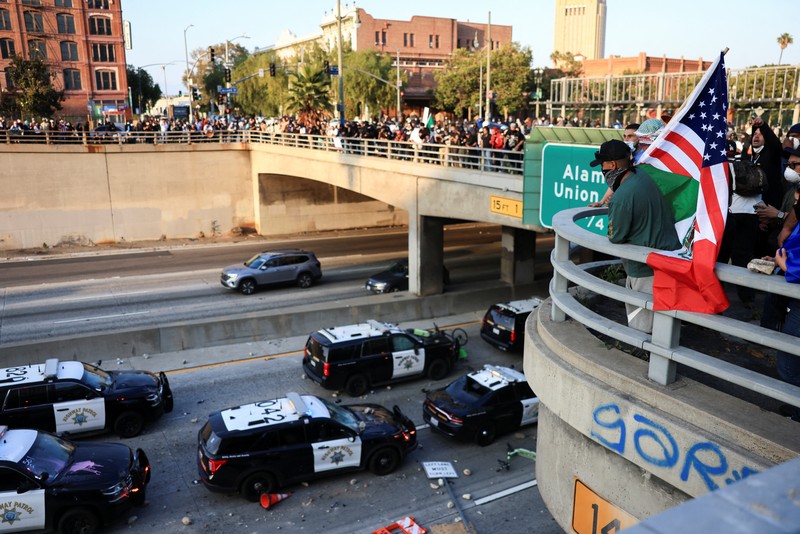 Kendaraan polisi yang rusak selama protes terhadap pemeriksaan imigrasi federal, di pusat kota Los Angeles, California, AS, 8 Juni 2025. (REUTERS/David Swanson)