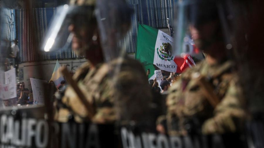 Para demonstran berkumpul di depan pasukan Garda Nasional California dan petugas penegak hukum, saat protes terhadap pemeriksaan imigrasi berlanjut, di Los Angeles, California, AS, 9 Juni 2025. Para demonstran berkumpul di depan pasukan Garda Nasional California dan petugas penegak hukum, saat protes terhadap pemeriksaan imigrasi berlanjut, di Los Angeles, California, AS, 9 Juni 2025. (REUTERS/Daniel Cole)