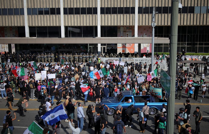 Para demonstran berkumpul di depan pasukan Garda Nasional California dan petugas penegak hukum, saat protes terhadap pemeriksaan imigrasi berlanjut, di Los Angeles, California, AS, 9 Juni 2025. Para demonstran berkumpul di depan pasukan Garda Nasional California dan petugas penegak hukum, saat protes terhadap pemeriksaan imigrasi berlanjut, di Los Angeles, California, AS, 9 Juni 2025. (REUTERS/Daniel Cole)