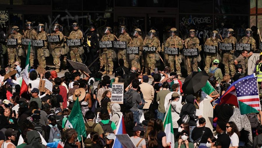 Pasukan Garda Nasional California dan petugas polisi berjaga saat orang-orang menghadiri unjuk rasa menentang penyisiran imigrasi federal, di Los Angeles, California, AS, 9 Juni 2025. (REUTERS/David Ryder)