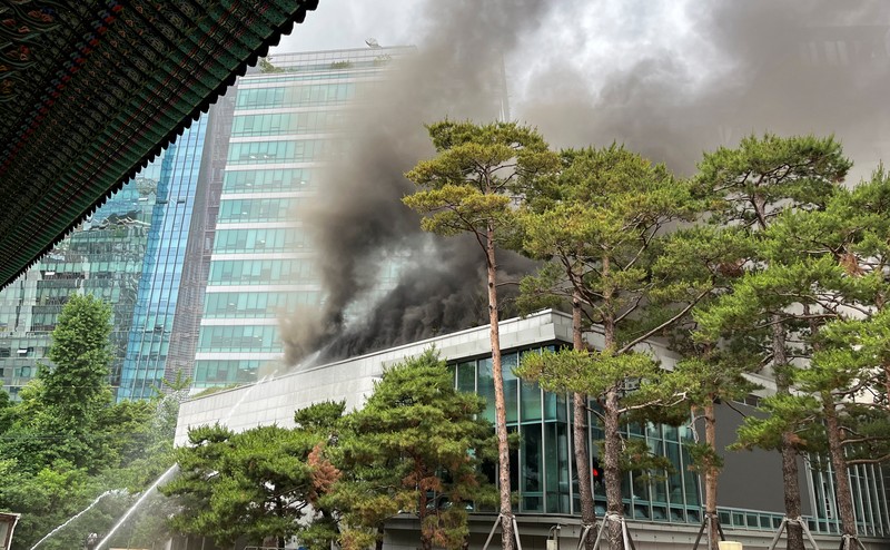 Orang-orang berjalan melewati mobil pemadam kebakaran saat kebakaran terjadi di gedung Museum Buddha Pusat di sebelah Kuil Jogye di Seoul, Korea Selatan, 10 Juni 2025. Orang-orang berjalan melewati mobil pemadam kebakaran saat kebakaran terjadi di gedung Museum Buddha Pusat di sebelah Kuil Jogye di Seoul, Korea Selatan, 10 Juni 2025. (REUTERS/Josh Smith)