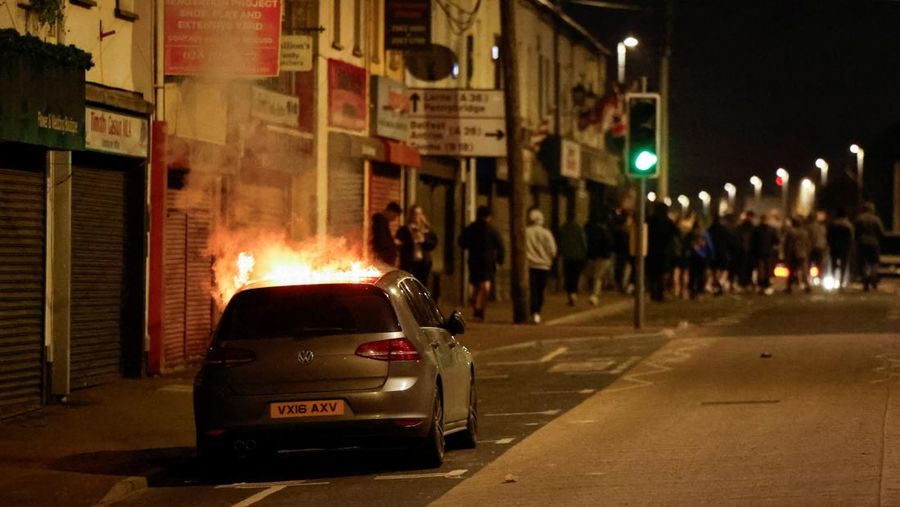 Seorang petugas polisi berjaga selama malam kedua kerusuhan, di Ballymena, Irlandia Utara, 10 Juni 2025. Seorang petugas polisi berjaga selama malam kedua kerusuhan, di Ballymena, Irlandia Utara, 10 Juni 2025. (REUTERS/Clodagh Kilcoyne)