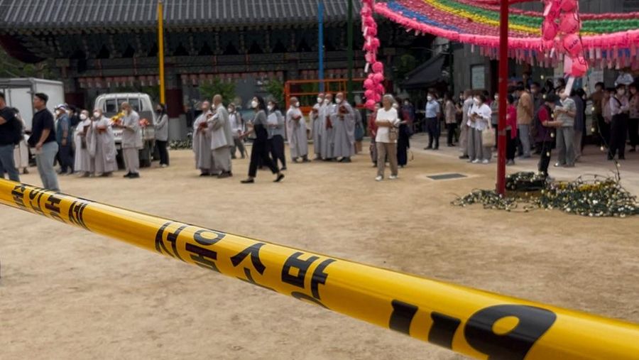 Orang-orang berjalan melewati mobil pemadam kebakaran saat kebakaran terjadi di gedung Museum Buddha Pusat di sebelah Kuil Jogye di Seoul, Korea Selatan, 10 Juni 2025. (REUTERS/Josh Smith)