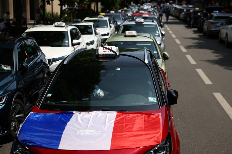 Pengemudi taksi Prancis yang mogok memblokir jalan dengan mobil taksi mereka di dekat Kementerian Ekonomi dan Keuangan Bercy, Paris, Prancis, Rabu (11/6/2025). (REUTERS/Abdul Saboor)