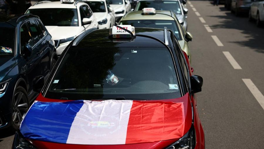 Pengemudi taksi Prancis yang mogok memblokir jalan dengan mobil taksi mereka di dekat Kementerian Ekonomi dan Keuangan Bercy, Paris, Prancis, Rabu (11/6/2025). (REUTERS/Abdul Saboor)