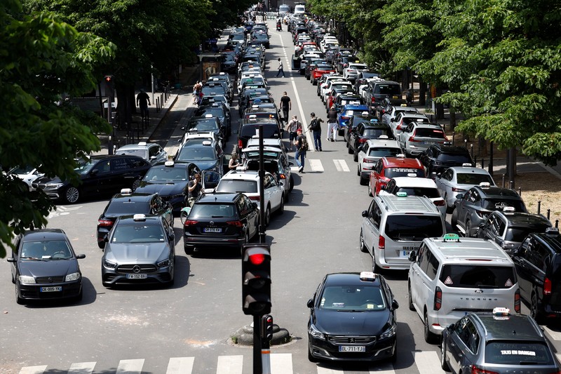 Pengemudi taksi Prancis yang mogok memblokir jalan dengan mobil taksi mereka di dekat Kementerian Ekonomi dan Keuangan Bercy, Paris, Prancis, Rabu (11/6/2025). (REUTERS/Abdul Saboor)