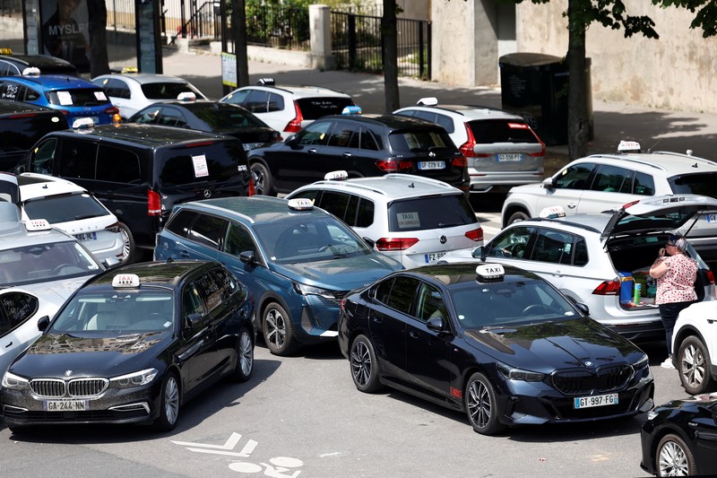 Pengemudi taksi Prancis yang mogok memblokir jalan dengan mobil taksi mereka di dekat Kementerian Ekonomi dan Keuangan Bercy, Paris, Prancis, Rabu (11/6/2025). (REUTERS/Abdul Saboor)