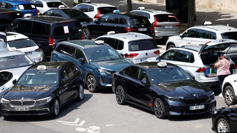 Pengemudi taksi Prancis yang mogok memblokir jalan dengan mobil taksi mereka di dekat Kementerian Ekonomi dan Keuangan Bercy, Paris, Prancis, Rabu (11/6/2025). (REUTERS/Abdul Saboor)