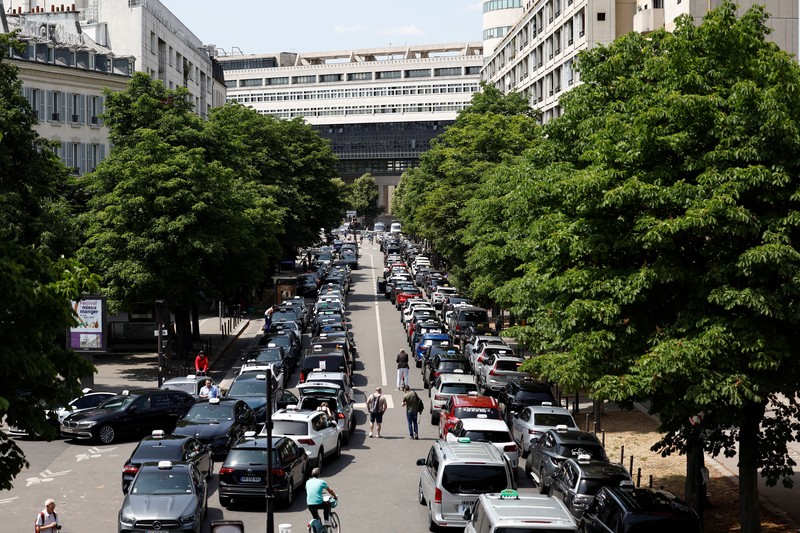 Pengemudi taksi Prancis yang mogok memblokir jalan dengan mobil taksi mereka di dekat Kementerian Ekonomi dan Keuangan Bercy, Paris, Prancis, Rabu (11/6/2025). (REUTERS/Abdul Saboor)
