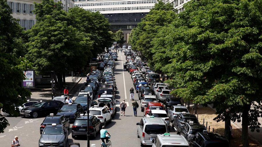 Pengemudi taksi Prancis yang mogok memblokir jalan dengan mobil taksi mereka di dekat Kementerian Ekonomi dan Keuangan Bercy, Paris, Prancis, Rabu (11/6/2025). (REUTERS/Abdul Saboor)