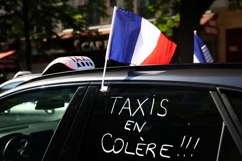 Pengemudi taksi Prancis yang mogok memblokir jalan dengan mobil taksi mereka di dekat Kementerian Ekonomi dan Keuangan Bercy, Paris, Prancis, Rabu (11/6/2025). (REUTERS/Abdul Saboor)