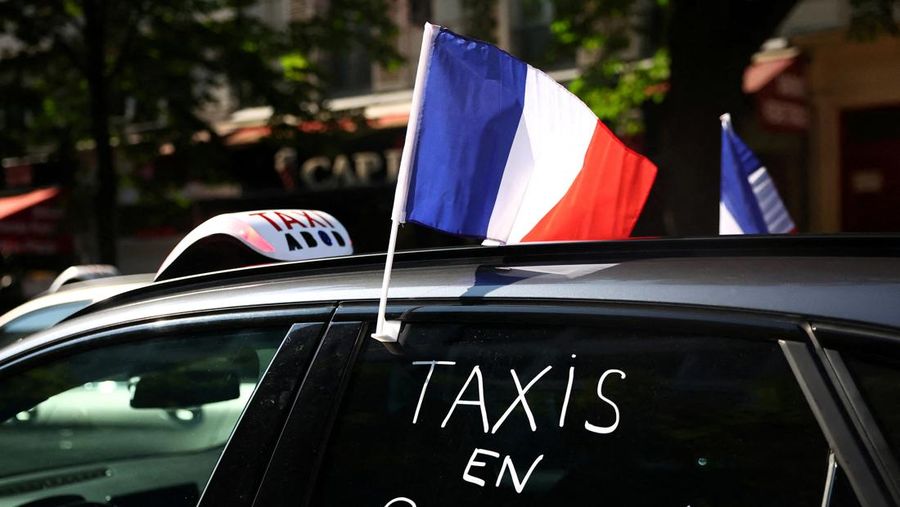 Pengemudi taksi Prancis yang mogok memblokir jalan dengan mobil taksi mereka di dekat Kementerian Ekonomi dan Keuangan Bercy, Paris, Prancis, Rabu (11/6/2025). (REUTERS/Abdul Saboor)