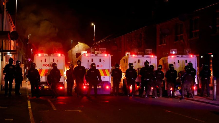 Seorang petugas polisi berjaga selama malam kedua kerusuhan, di Ballymena, Irlandia Utara, 10 Juni 2025. (REUTERS/Clodagh Kilcoyne)