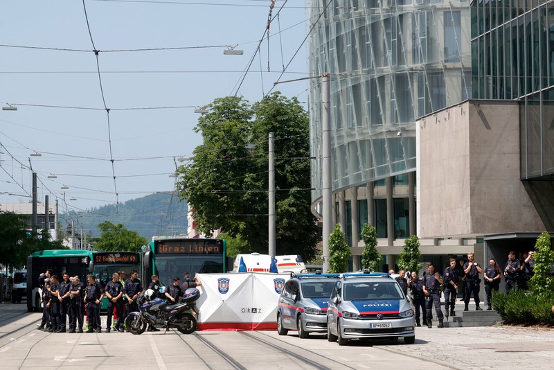 Petugas polisi berdiri saat anak-anak dievakuasi dari sekolah, setelah penembakan sekolah yang mematikan di Graz, Austria, 10 Juni 2025. Petugas polisi berdiri saat anak-anak dievakuasi dari sekolah, setelah penembakan sekolah yang mematikan di Graz, Austria, 10 Juni 2025. (REUTERS/Borut Zivulovic)