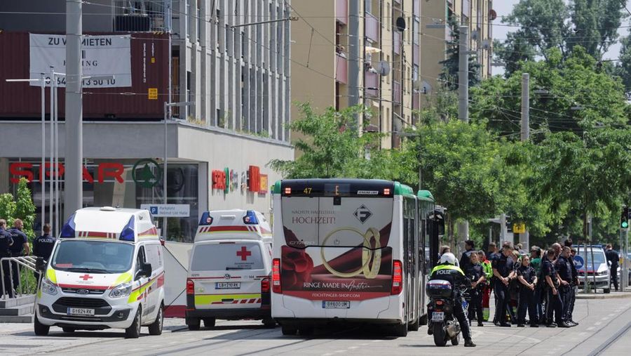 Petugas polisi berdiri saat anak-anak dievakuasi dari sekolah, setelah penembakan sekolah yang mematikan di Graz, Austria, 10 Juni 2025. (REUTERS/Borut Zivulovic)