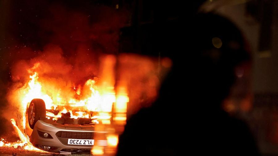 Seorang petugas polisi berjaga selama malam kedua kerusuhan, di Ballymena, Irlandia Utara, 10 Juni 2025. Seorang petugas polisi berjaga selama malam kedua kerusuhan, di Ballymena, Irlandia Utara, 10 Juni 2025. (REUTERS/Clodagh Kilcoyne)