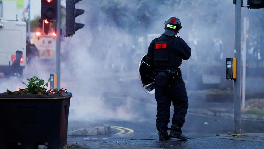 Seorang petugas polisi berjaga selama malam kedua kerusuhan, di Ballymena, Irlandia Utara, 10 Juni 2025. Seorang petugas polisi berjaga selama malam kedua kerusuhan, di Ballymena, Irlandia Utara, 10 Juni 2025. (REUTERS/Clodagh Kilcoyne)