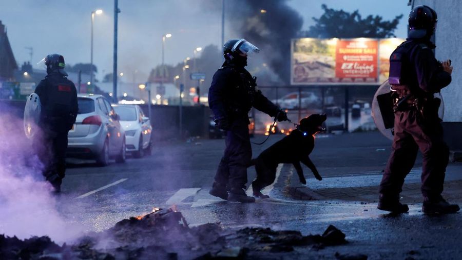 Seorang petugas polisi berjaga selama malam kedua kerusuhan, di Ballymena, Irlandia Utara, 10 Juni 2025. (REUTERS/Clodagh Kilcoyne)