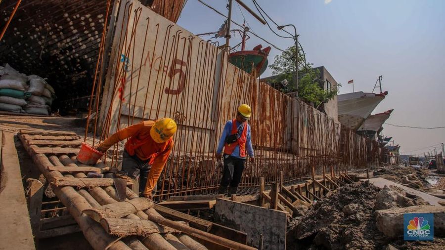 Pekerja menyelesaikan pembangunan tanggul mitigasi di Jalan Mandala Bahari, Pluit, Penjaringan, Jakarta, Kamis (12/6/2025). (CNBC Indonesia/Faisal Rahman)