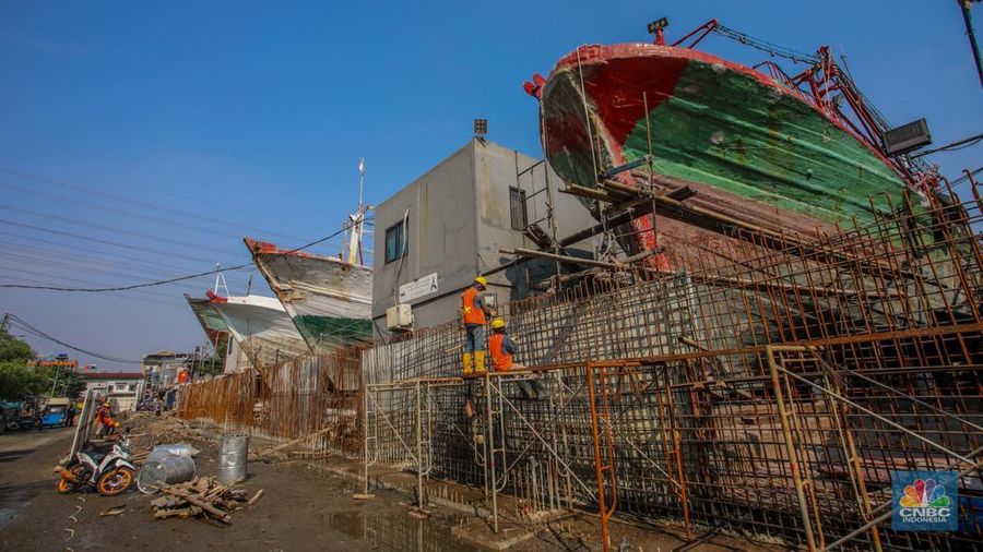 Pekerja menyelesaikan pembangunan tanggul mitigasi di Jalan Mandala Bahari, Pluit, Penjaringan, Jakarta, Kamis (12/6/2025). (CNBC Indonesia/Faisal Rahman)