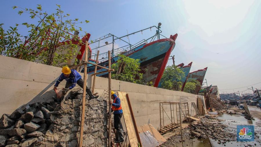 Pekerja menyelesaikan pembangunan tanggul mitigasi di Jalan Mandala Bahari, Pluit, Penjaringan, Jakarta, Kamis (12/6/2025). (CNBC Indonesia/Faisal Rahman)