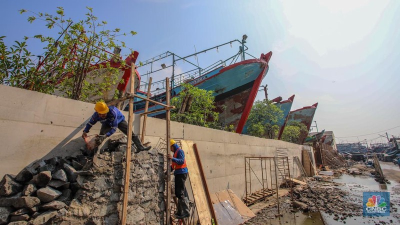 Pekerja menyelesaikan pembangunan tanggul mitigasi di Jalan Mandala Bahari, Pluit, Penjaringan, Jakarta, Kamis (12/6/2025). (CNBC Indonesia/Faisal Rahman)