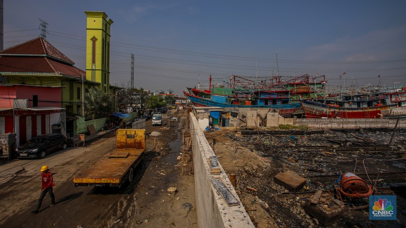 Pekerja menyelesaikan pembangunan tanggul mitigasi di Jalan Mandala Bahari, Pluit, Penjaringan, Jakarta, Kamis (12/6/2025). (CNBC Indonesia/Faisal Rahman)