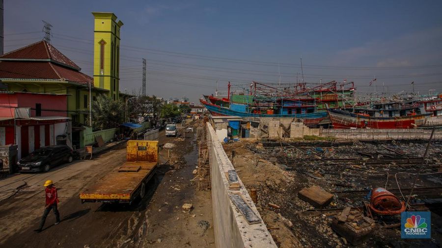 Pekerja menyelesaikan pembangunan tanggul mitigasi di Jalan Mandala Bahari, Pluit, Penjaringan, Jakarta, Kamis (12/6/2025). (CNBC Indonesia/Faisal Rahman)