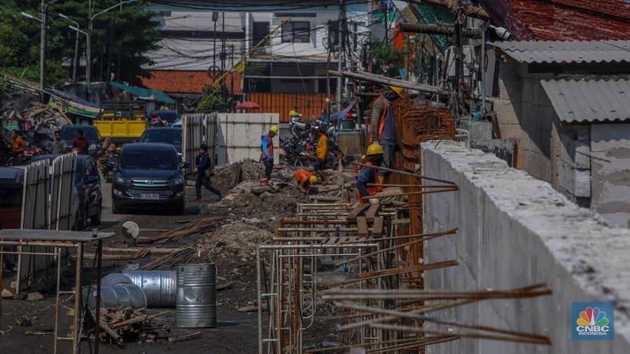 Pekerja menyelesaikan pembangunan tanggul mitigasi di Jalan Mandala Bahari, Pluit, Penjaringan, Jakarta, Kamis (12/6/2025). (CNBC Indonesia/Faisal Rahman)