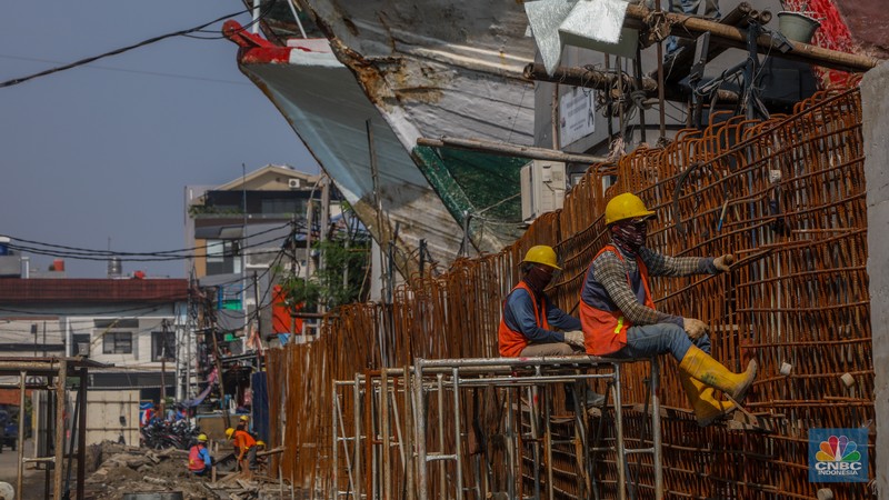 Pekerja menyelesaikan pembangunan tanggul mitigasi di Jalan Mandala Bahari, Pluit, Penjaringan, Jakarta, Kamis (12/6/2025). (CNBC Indonesia/Faisal Rahman)