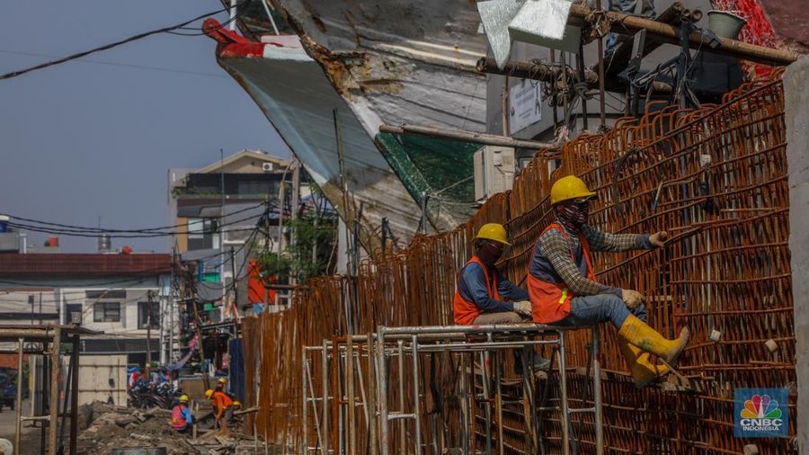 Pekerja menyelesaikan pembangunan tanggul mitigasi di Jalan Mandala Bahari, Pluit, Penjaringan, Jakarta, Kamis (12/6/2025). (CNBC Indonesia/Faisal Rahman)