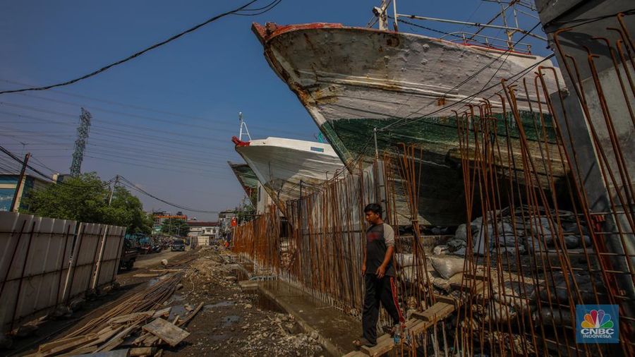 Pekerja menyelesaikan pembangunan tanggul mitigasi di Jalan Mandala Bahari, Pluit, Penjaringan, Jakarta, Kamis (12/6/2025). (CNBC Indonesia/Faisal Rahman)