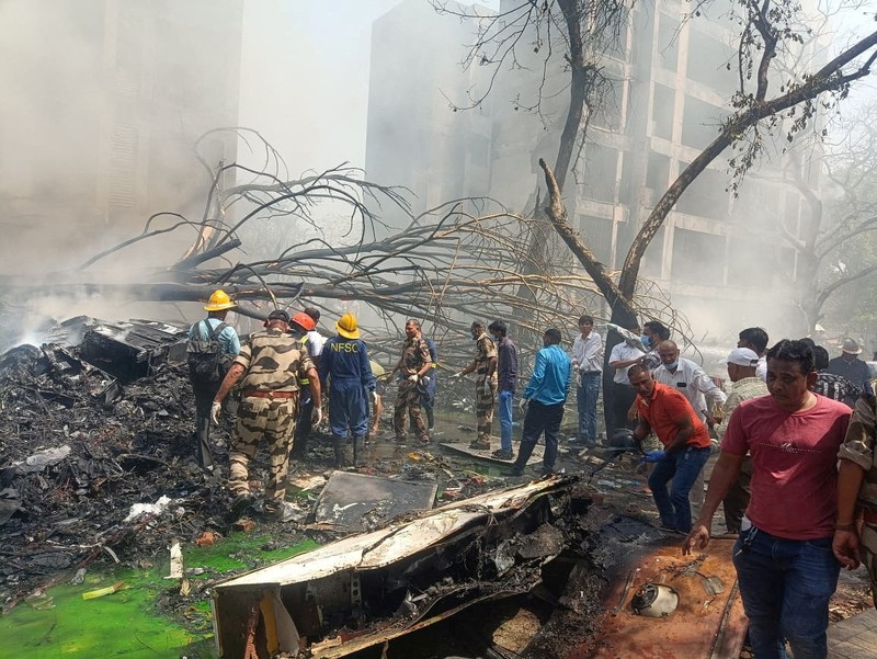 Anggota tim penyelamat bekerja saat asap mengepul di lokasi jatuhnya pesawat Air India di Ahmedabad, India, 12 Juni 2025. Anggota tim penyelamat bekerja saat asap mengepul di lokasi jatuhnya pesawat Air India di Ahmedabad, India, 12 Juni 2025. (REUTERS/Amit Dave)