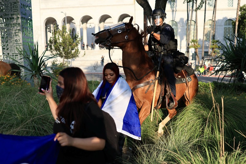 Police officers ride horses as they attempt to disperse protesters demonstrating against federal immigration sweeps, in downtown Los Angeles, California, U.S. June 11, 2025.  REUTERS/David Ryder