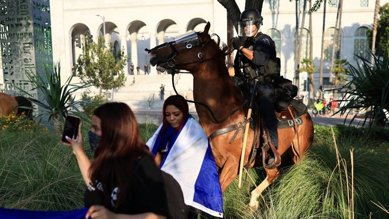Police officers ride horses as they attempt to disperse protesters demonstrating against federal immigration sweeps, in downtown Los Angeles, California, U.S. June 11, 2025.  REUTERS/David Ryder