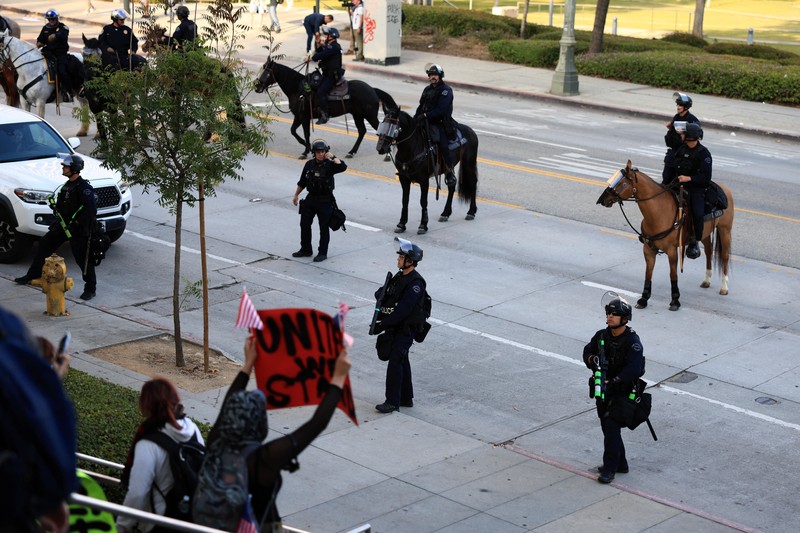 Police officers ride horses as they attempt to disperse protesters demonstrating against federal immigration sweeps, in downtown Los Angeles, California, U.S. June 11, 2025.  REUTERS/David Ryder