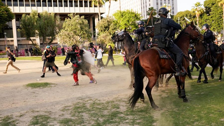 USA-MIGRATION/PROTEST-LOS ANGELES Police officers ride horses as they attempt to disperse protesters demonstrating against federal immigration sweeps, in downtown Los Angeles, California, U.S. June 11, 2025. REUTERS/David Ryder