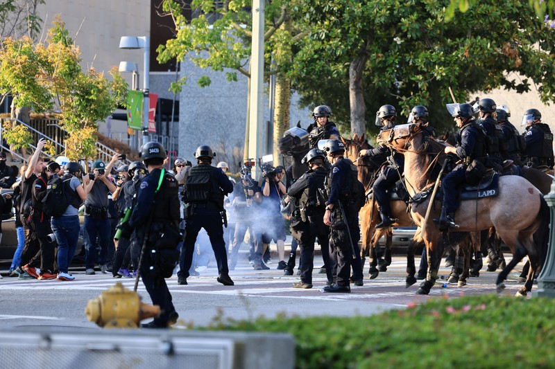 Police officers ride horses as they attempt to disperse protesters demonstrating against federal immigration sweeps, in downtown Los Angeles, California, U.S. June 11, 2025.  REUTERS/David Ryder