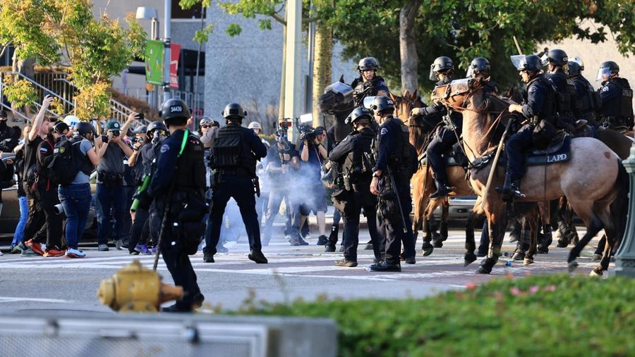 USA-MIGRATION/PROTEST-LOS ANGELES Police officers ride horses as they attempt to disperse protesters demonstrating against federal immigration sweeps, in downtown Los Angeles, California, U.S. June 11, 2025. REUTERS/David Ryder
