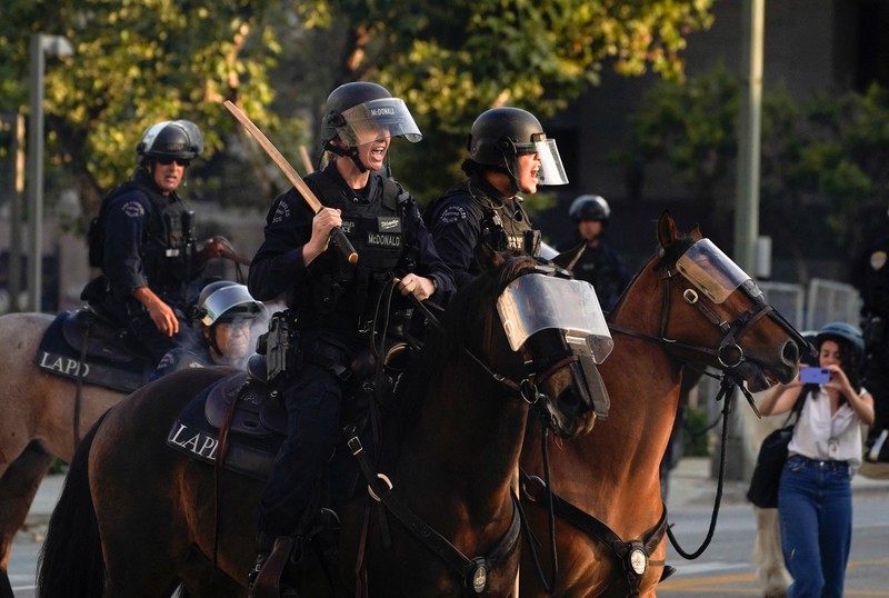 Police officers ride horses as they attempt to disperse protesters demonstrating against federal immigration sweeps, in downtown Los Angeles, California, U.S. June 11, 2025.  REUTERS/David Ryder