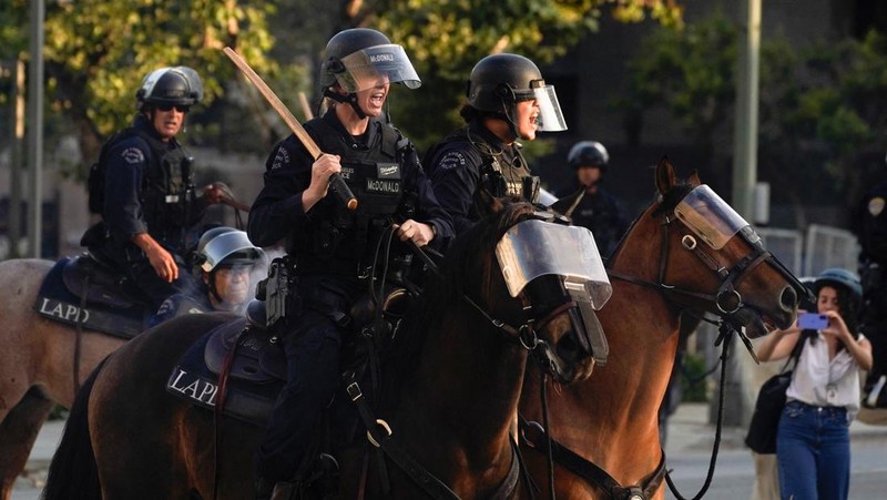 Police officers ride horses as they attempt to disperse protesters demonstrating against federal immigration sweeps, in downtown Los Angeles, California, U.S. June 11, 2025.  REUTERS/David Ryder