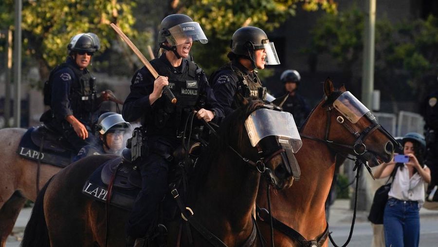 USA-MIGRATION/PROTEST-LOS ANGELES Police officers ride horses as they attempt to disperse protesters demonstrating against federal immigration sweeps, in downtown Los Angeles, California, U.S. June 11, 2025. REUTERS/David Ryder