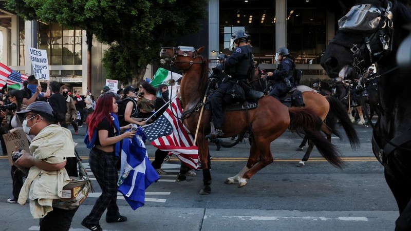 Police officers ride horses as they attempt to disperse protesters demonstrating against federal immigration sweeps, in downtown Los Angeles, California, U.S. June 11, 2025.  REUTERS/David Ryder