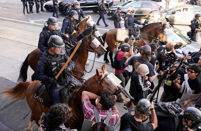 USA-MIGRATION/PROTEST-LOS ANGELES Police officers ride horses as they attempt to disperse protesters demonstrating against federal immigration sweeps, in downtown Los Angeles, California, U.S. June 11, 2025. REUTERS/David Ryder